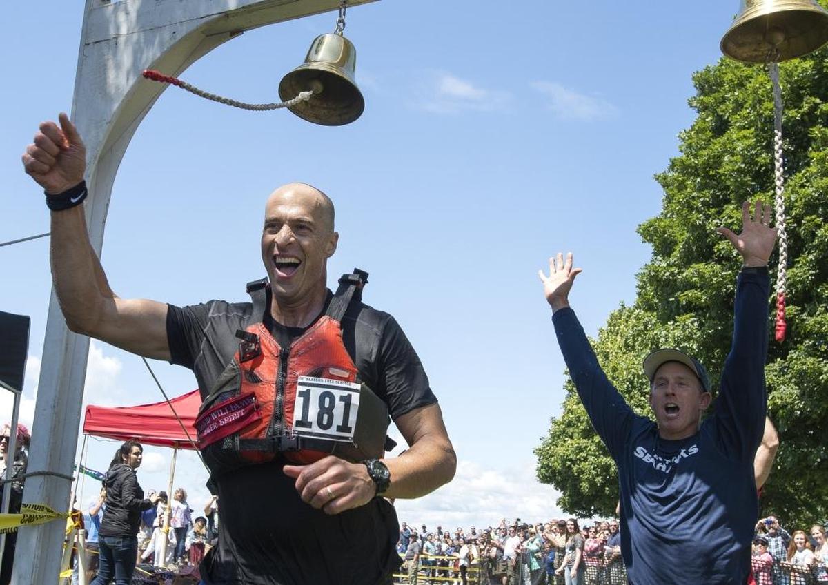 Brandon Nelson, left, of team Beavers Tree Service is joined by his teammate Michael Lee as he crosses the finish line in first place at 2016 Ski to Seaat Marine Park in Bellingham.
