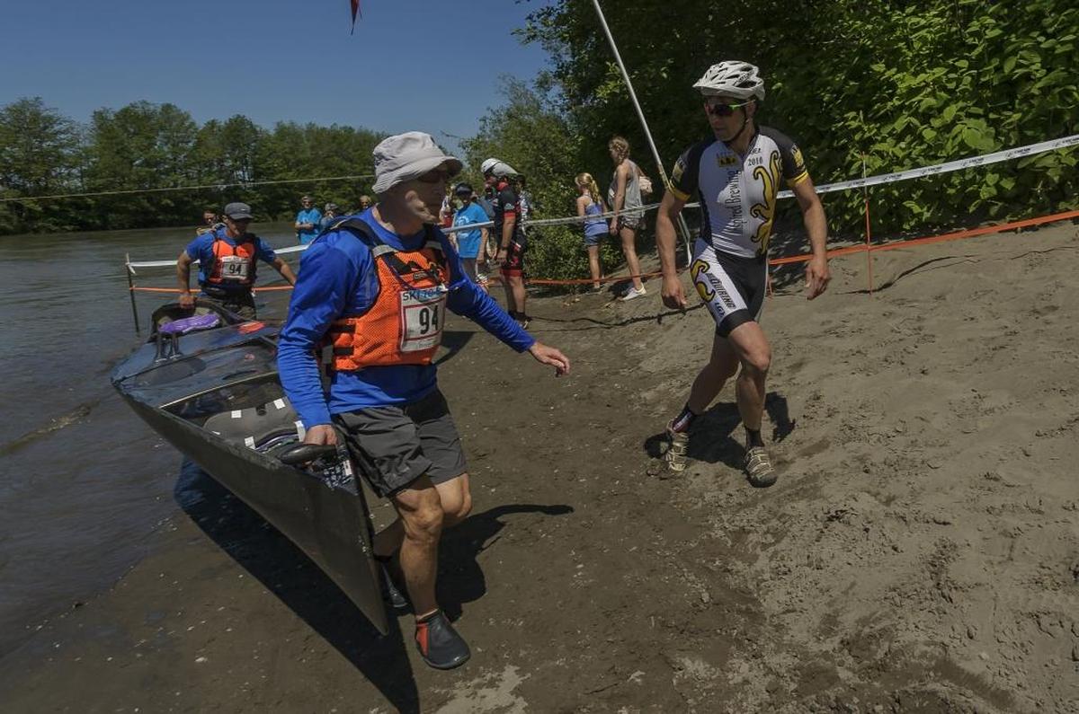 Steve Dempsey, right, of Bellingham, helps teammates Eric Gerstl and Michael Hammer out of the Nooksack River at the canoe to cyclocross transfer of the 2017 Ski to Sea.
