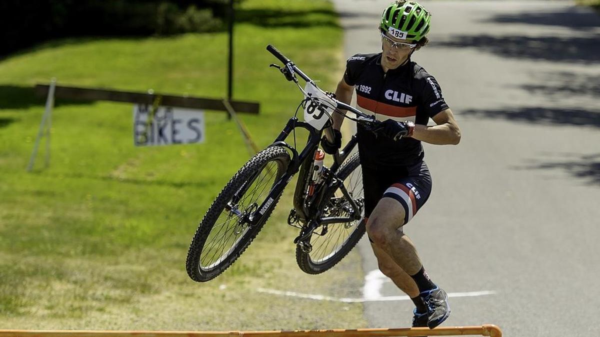Logan Wetzel with Klicks Running & Walking hops over the dismount barrier at the finish line of the 2015 Ski to Sea race in Fairhaven. Klicks Running & Walking came won 1st in the Whatcom County open division and 3rd place overall.