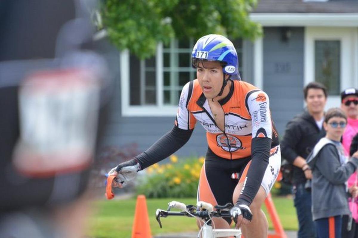 Michael Finley, the cyclist with the Boomer’s Drive-In team, crosses the finish line at Everson’s Riverside Park after biking about 15 miles with a dislocated shoulder he sustained in a fall on Sunday, May 29, 2016.