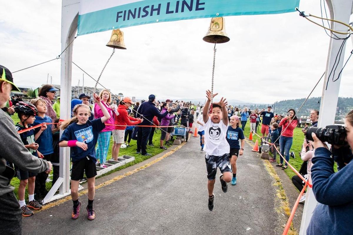 Competitors race to the finish line bell at the 2018 Junior Ski to Sea relay race in Bellingham. This year's race will occur Saturday, May 18, at Squalicum Creek Park in Bellingham.