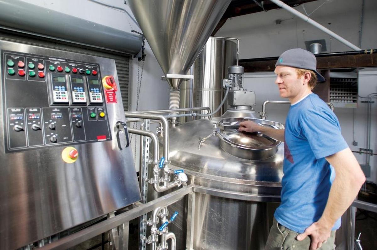 Chad Kuehl, co-owner of Wander Brewing, tends to a brew in April 2014.