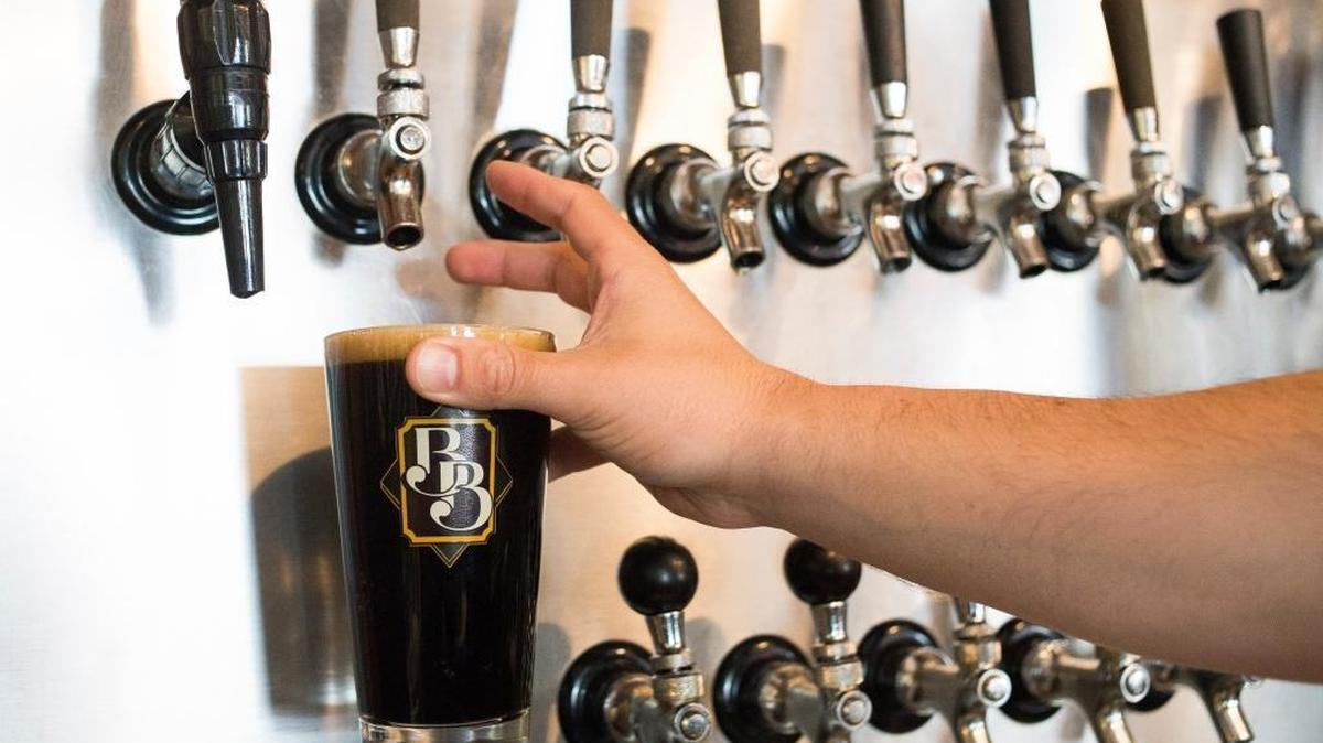 A server pours an oatmeal stout at Boundary Bay Brewery in this 2017 file photo.