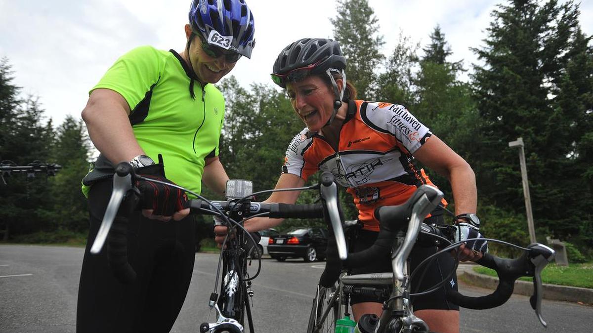 Cycling coach Robin Robertson helps Kevin Williamson adjust his cycling speedometer before they start their training session for the Mt. Baker Hill Climb on Tuesday, August 10, 2010, at Lake Padden Park. Robertson has written a book about cycling and saving damaged knees.