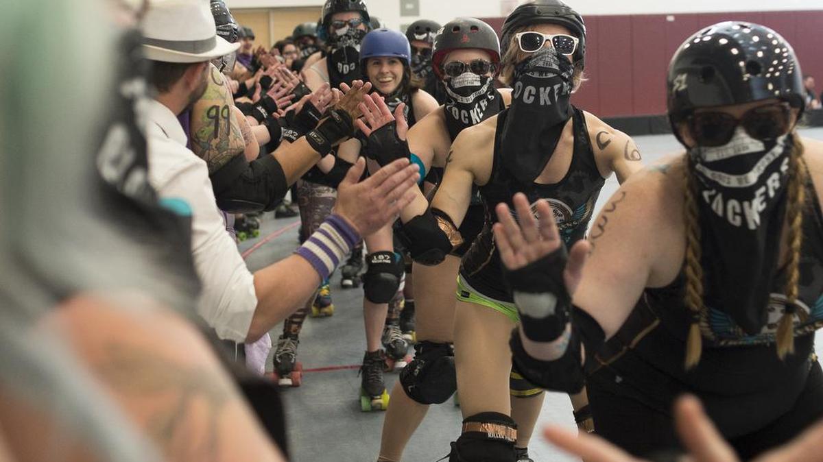 Cog Blockers, right, greet their opponents, Tough Love, before the start of the Bellingham Roller Betties League championship match on Saturday, June 10, in Bellingham, Washington.
