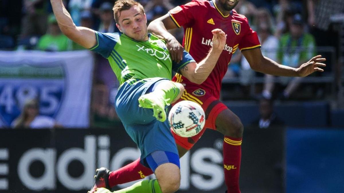 The Sounders’ Jordan Morris, left, attacks but Real Salt Lake’s Aaron Maund gets a hand on his shoulder to disrupt Morris’ shot late in the first half.