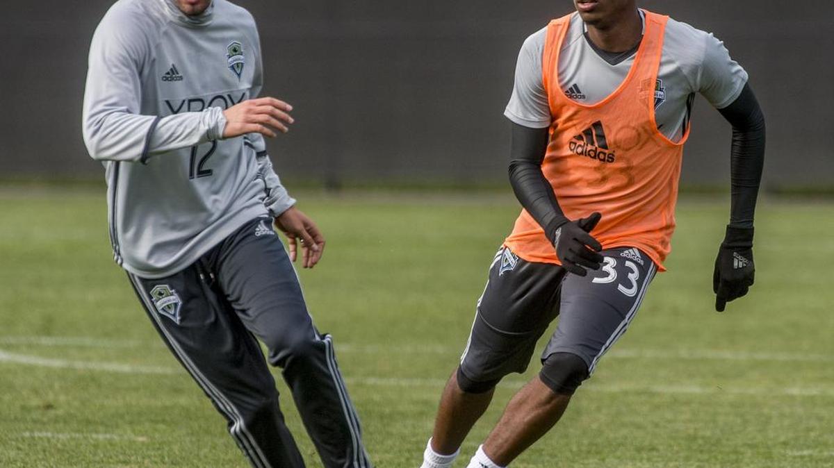 Seattle midfielder Michael Farfan and defender Joevin Jones, right, go through a drill at training camp in Tukwila on January 25, 2016.