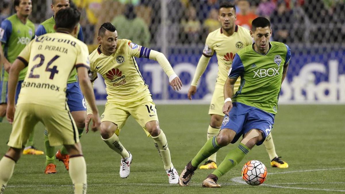 Sounders forward Clint Dempsey dribbles away from the Club America defense Tuesday. Dempsey scored twice in the, 2-2, draw.