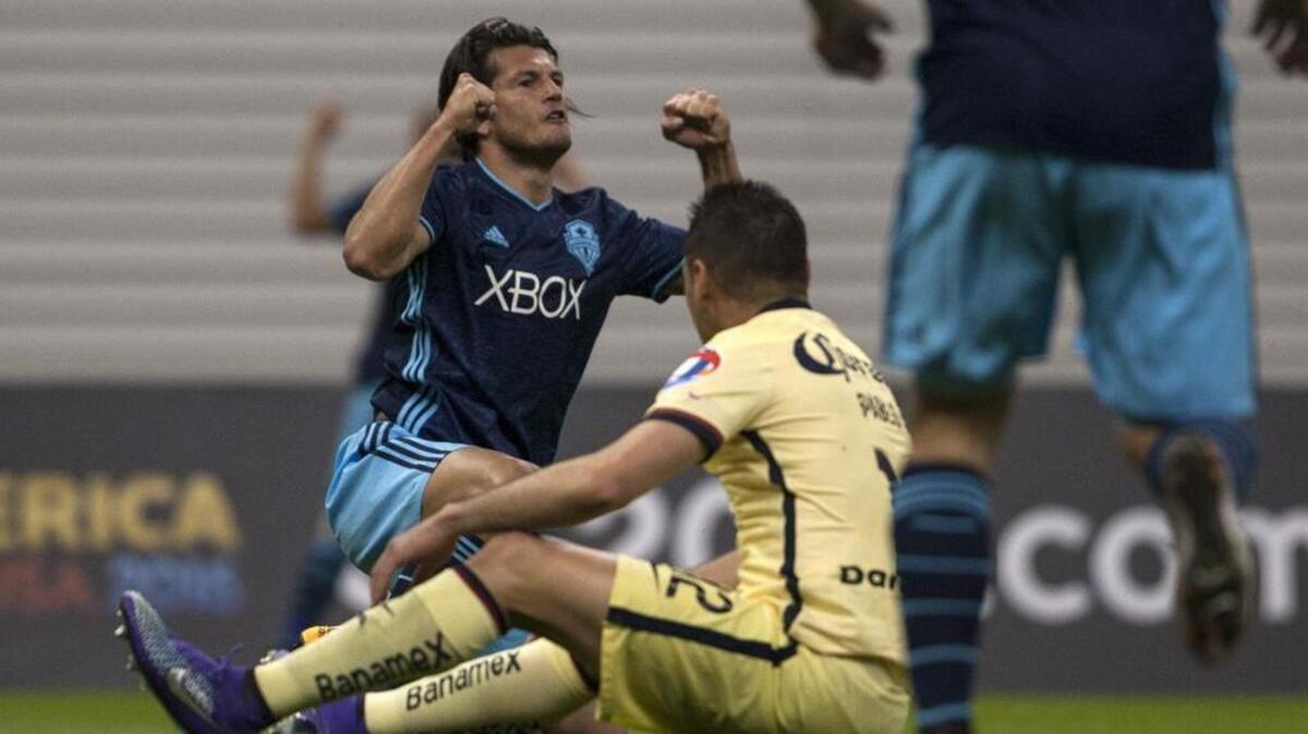 Seattle’s Nelson Valdez, left, celebrates in front of Club America’s Pablo Aguilar after his shot deflected off the defender for a goal during a CONCACAF Champions league match in Mexico City on Wednesday, March 2, 2016.