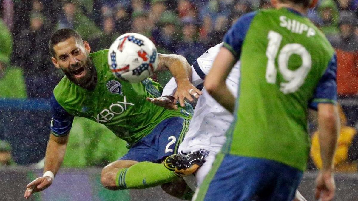 Seattle Sounders midfielder Clint Dempsey, left, kicks the ball away from Vancouver Whitecaps midfielder Aly Ghazal as Sounders’ Harrison Shipp looks on during the MLS soccer Western Conference semifinal Nov. 2, 2017 in Seattle.