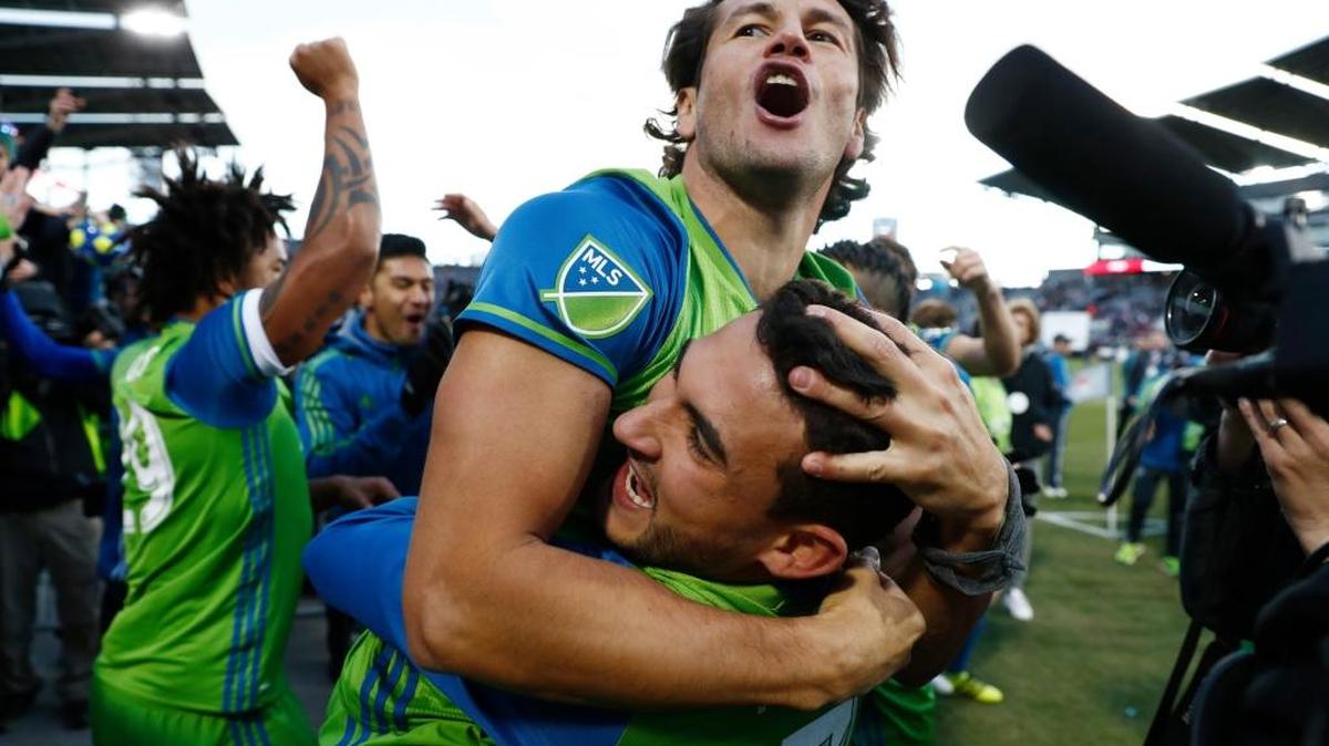 Seattle Sounders forward Nelson Haedo Valdez, top, hugs midfielder Cristian Roldan after defeating the Colorado Rapids in the second leg of the MLS Western Conference soccer finals game Sunday, Nov. 27, 2016, in Commerce City, Colo.