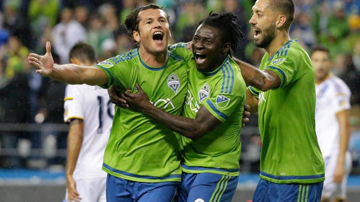 Seattle Sounders' Nelson Valdez, left, celebrates with teammates Obafemi Martins, center, and Clint Dempsey, right, after Valdez scored a goal against the Los Angeles Galaxy in the first half of an MLS soccer western conference knockout round playoff match, Wednesday, Oct. 28, 2015, in Seattle.