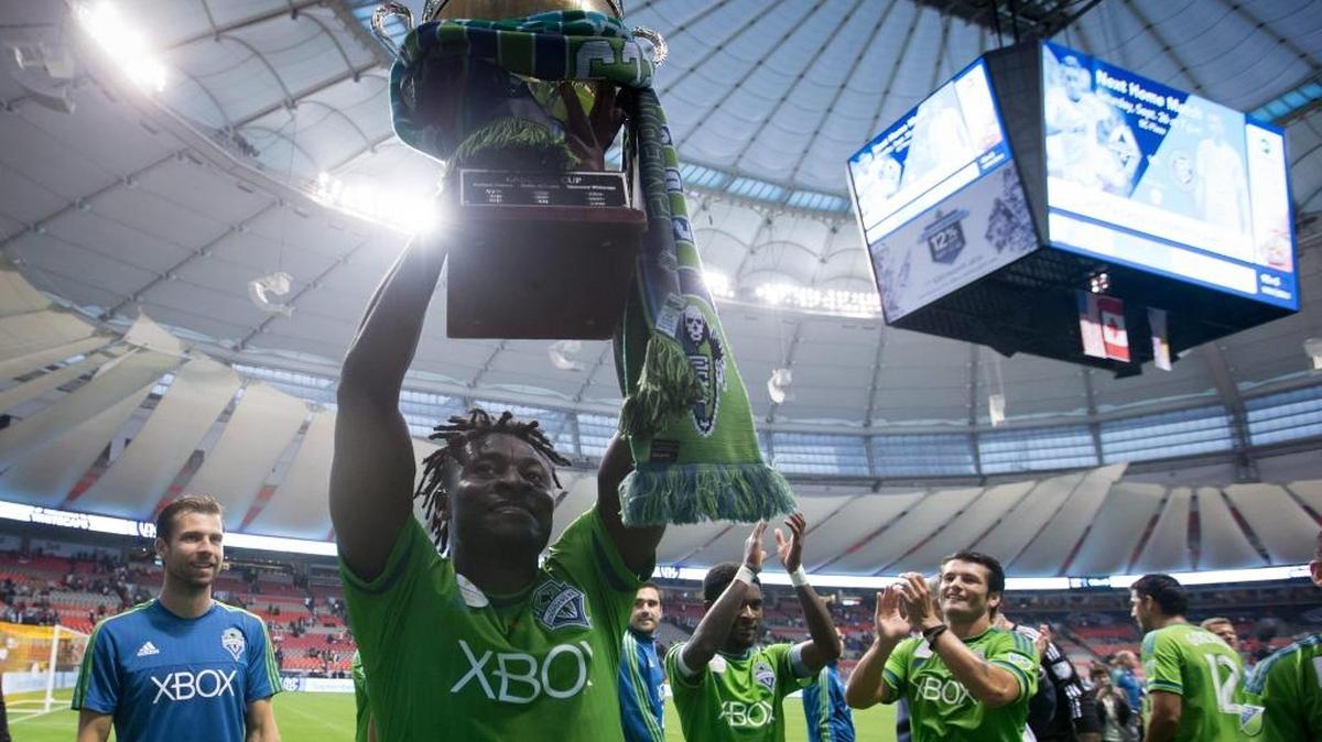 
Seattle Sounders' Obafemi Martins, of Nigeria, hoists the Cascadia Cup to the team's supporters after defeating the Vancouver Whitecaps during an MLS soccer game in Vancouver, British Columbia, on Saturday, Sept. 19, 2015. The trophy was created by fans of the Vancouver Whitecaps, Seattle Sounders and Portland Timbers and is awarded to the best soccer team in the Pacific Northwest each MLS season.
