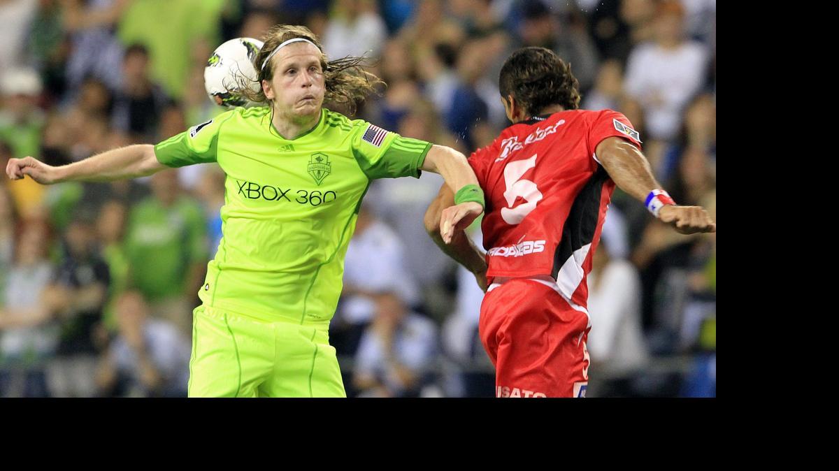 
Erik Friberg, left, goes to head the ball in a match in August 2011. He’s back with the Sounders, but no one’s saying how soon he’ll see action.
