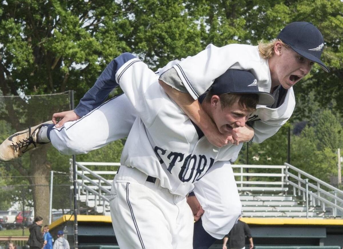 Squalicum's Ernie Yake jumps onto the back of Connor Sage after defeating Anacortes to advance to the semifinal round of the 2A State Baseball Championships on Saturday, May 23, at Joe Martin Field in Bellingham, Washington.
