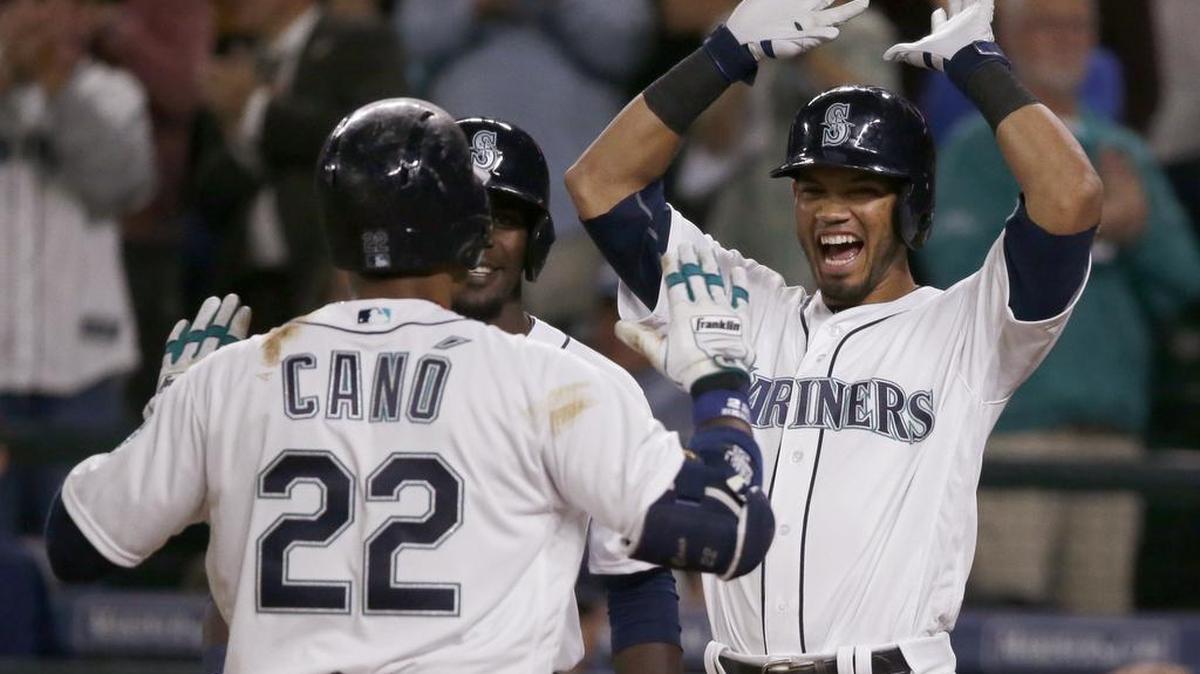 Luis Sardinas, right, and Guillermo Heredia greet Robinson Cano, who hit a three-run homer to cap the Mariners’ five-run eighth against Boston.