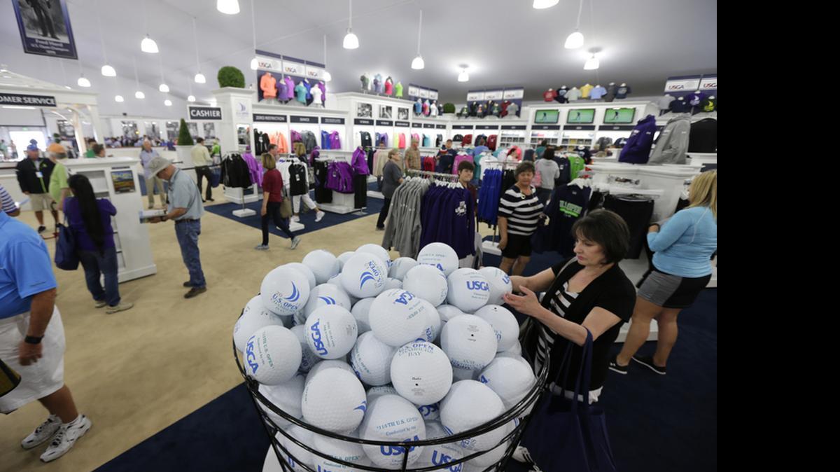 
Shoppers check out giant souvenir rubber golf balls and other items as they shop in the merchandise pavilion at Chambers Bay golf course in University Place, Wash., Thursday, June 11, 2015. Chambers Bay will host the U.S. Open Championship next week, but the merchandise store and some other non-course areas are open to the public through this weekend.
