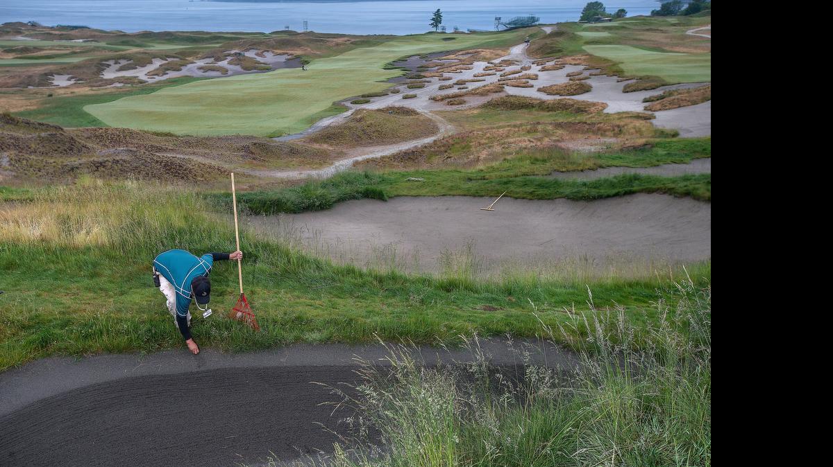 
Working in the early morning, turf crew member Richard Savas manicures the traps and fine fescue grasses around the fourth green.


